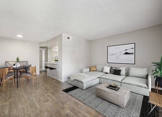 Model Living Room with Wood-Style Flooring and View of Dining Area at Country Club Verandas Apartments located in Mesa, AZ.