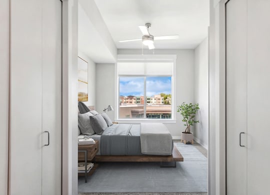 Model Bedroom with Carpet and Window View at Seven Skies Apartments located in Sandy, UT.