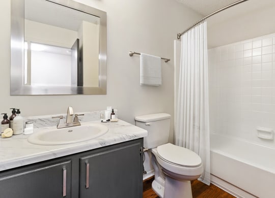Model Bathroom with Wood-Style Flooring and Shower/Tub at Grandstand Apartments in Marietta, GA.