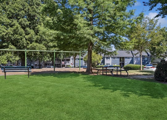 Community Swing Set and Picnic Tables at Lakeside Retreat Apartments located in Peachtree Corners, GA.