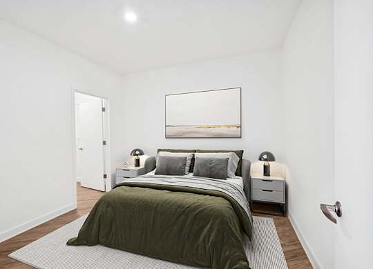 Model Bedroom with Wood-Style Flooring and attached Bathroom at Stella Apartments located in New Carrollton, MD.