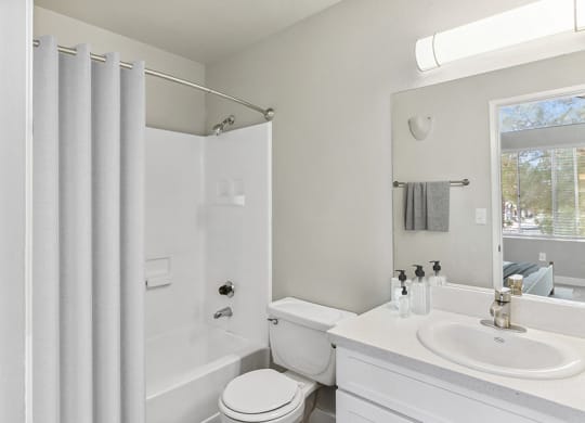 Model Bathroom with White Cabinets and Shower/Tub at Meadow Ridge Apartments in Las Vegas, NV.