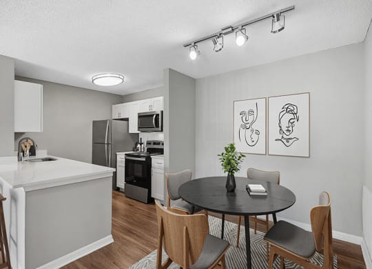 Model Dining Room and Kitchen Area with Wood-Style Flooring at Fountains Lee Vista Apartments in Orlando, FL.