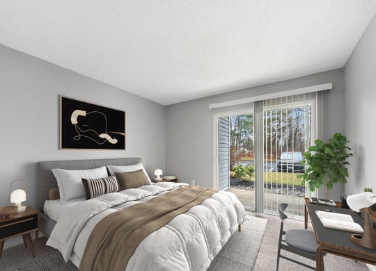 Model Bedroom with Carpet and Patio Accessibility at Commons at Haynes Farm Apartments in Shrewsbury, MA.