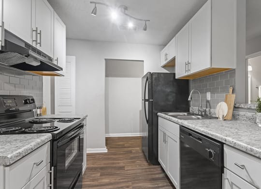 Model Kitchen with White Cabinets and Wood-Style Flooring at Corners at 1700 Apartments in Atlanta, GA.