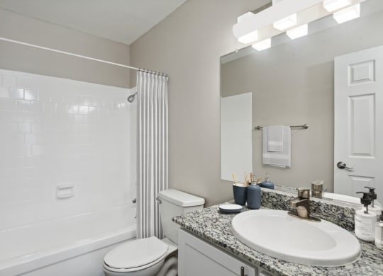 Model bathroom with a sink, toilet, and tub/shower