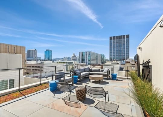 Rooftop lounge space with large TV and chairs at TL Residences