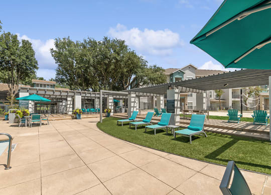 Community Swimming Pool with Pool Furniture at Essence Apartments in Dallas, TX.