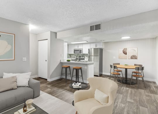 Model Living Room and Kitchen/Dining Room Area with Wood-Style Flooring at Meadow Ridge Apartments in Las Vegas, NV.