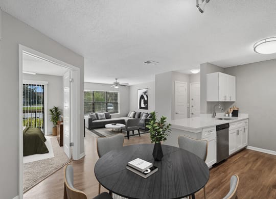 Model Living Room with Wood-Style Flooring and View of Kitchen and Living Room Area at Fountains Lee Vista Apartments in Orlando, FL.