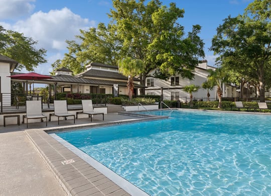 Community Swimming Pool with Pool Furniture at Rosehill Preserve Apartments located in Orlando, FL.