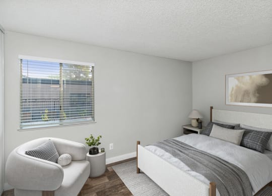 a bedroom with a bed and a chair and a window
