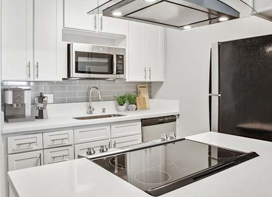 Model Kitchen with White Cabinets and Wood-Style Flooring at Cove La Mesa Apartments located in La Mesa, CA.