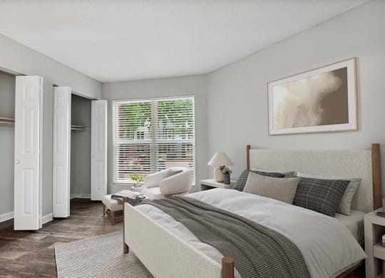 Model Bedroom with Double Closets and Wood-Style Flooring at Arbor Village Apartments in Charlotte, NC.