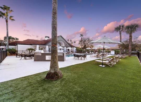 a resort style pool with lounge chairs and umbrellas