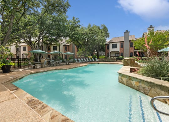 Community Swimming Pool with Pool Furniture at Dallas North Park Apartments in Dallas, TX.