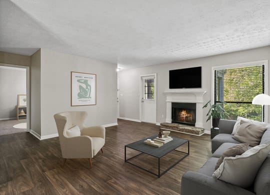 Model Living Room with Wood-Style Flooring and Fireplace at Lakeside Retreat Apartments located in Peachtree Corners, GA.