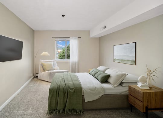 Model bedroom with a bed and a window at Stone Ends apartments in Stoughton, MA