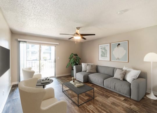 Model Living Room with Wood-Style Flooring and Sliding Glass Door at Indigo Park Apartments in Albuquerque, NM.