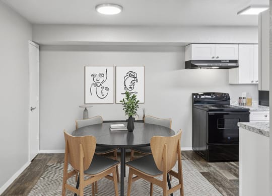 Model Dining Room with Wood-Style Flooring and View of Kitchen at Tanque Verde Apartments located in Tucson, AZ.
