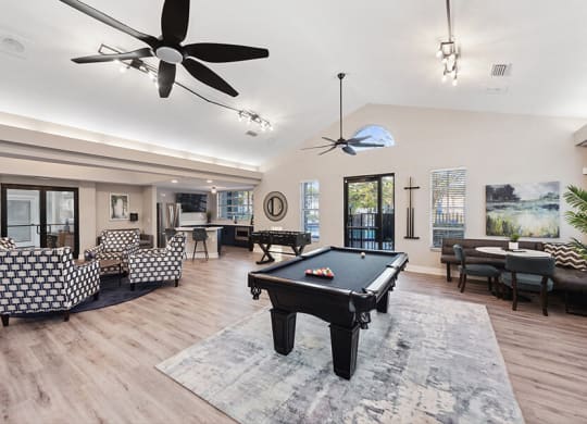 Community Clubhouse with Lounge Furniture and Pool Table Area at Vue at Baymeadows Apartments in Jacksonville, FL.