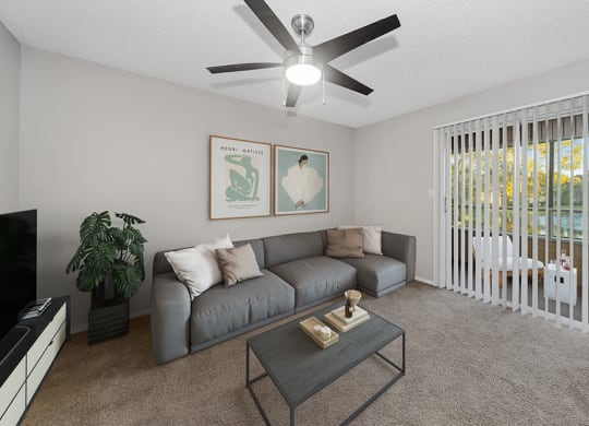 Model Living Room with Carpet and Patio Accessibility at Walden Lake Apartments in Plant City, FL.