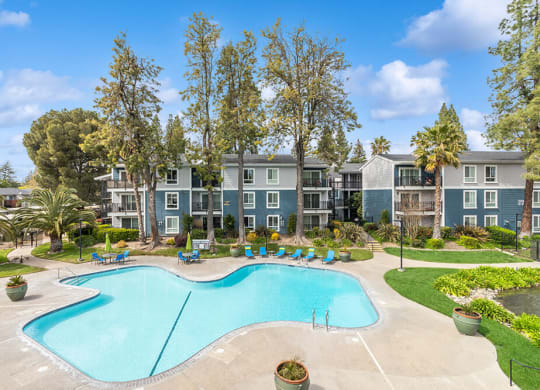 Community Swimming Pool with Pool Furniture at Fountains at Point West Apartments in Sacramento, CA.