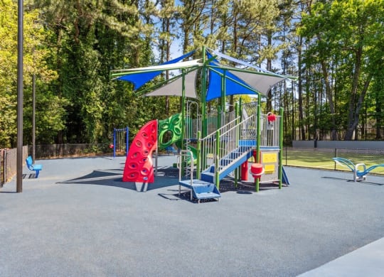Community Playground with a Blue and White Canopy at Dunwoody Village Apartments in Atlanta, GA.
