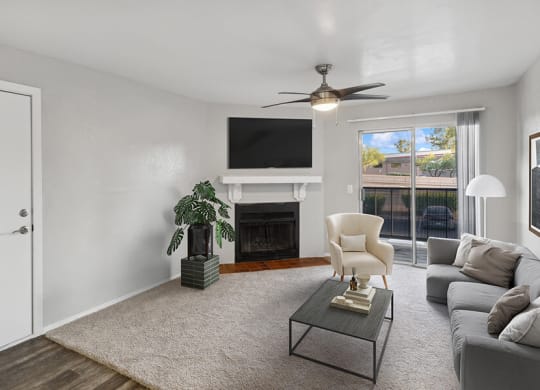 Model Living Room with Wood-Style Flooring, Fireplace and Patio Accessibility at Tanque Verde Apartments located in Tucson, AZ.