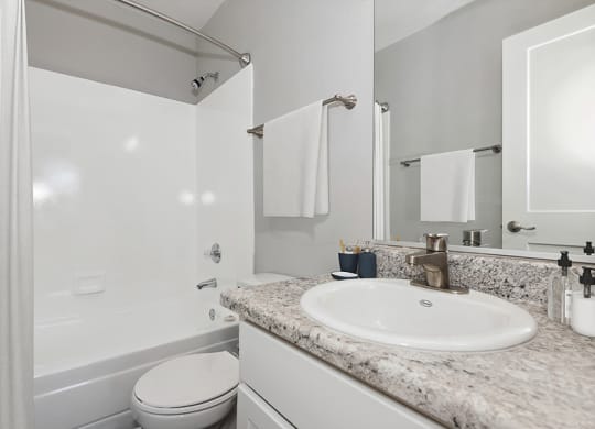 Model Bathroom with Wood-Style Flooring and Shower/Tub at Stillwater Apartments in Glendale, AZ.