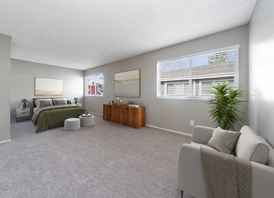 Model Bedroom with Carpet and Window View at Bridges at 9 Mile Station Apartments in Denver, CO.