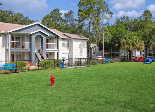Dog park with fire hydrant and agility equipment at Retreat at Crosstown Apartments