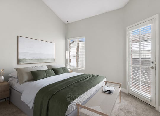 Model Bedroom with Carpet and Patio Accessibility at Crystal Creek Apartments in Phoenix, AZ.