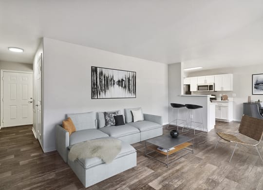 Model Living Room with Wood-Style Flooring, View of Dining Room & Patio Accessibility at Loma Vista Apartments in Las Vegas, NV.
