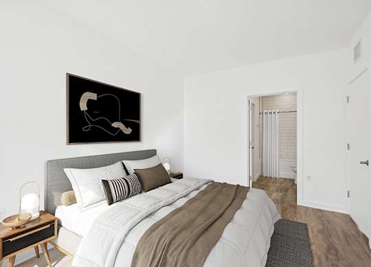 Model Bedroom with Wood-Style Flooring and attached Bathroom at Stella Apartments located in New Carrollton, MD.