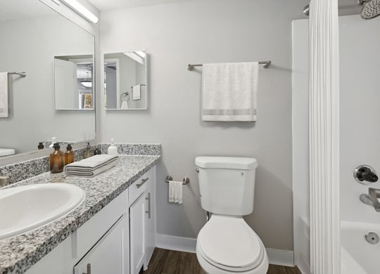 Model Bathroom with Wood-Style Flooring at Hilands Apartments in Tucson, AZ.