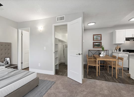 Model Studio Bedroom with Carpet and View of Dining Room at Stillwater Apartments in Glendale, AZ.