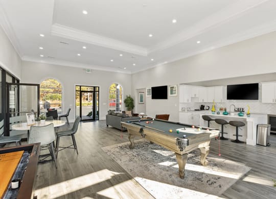 Community Clubhouse with Lounge Furniture and Game Tables at Shadow Ridge Apartments in Riverdale, GA.