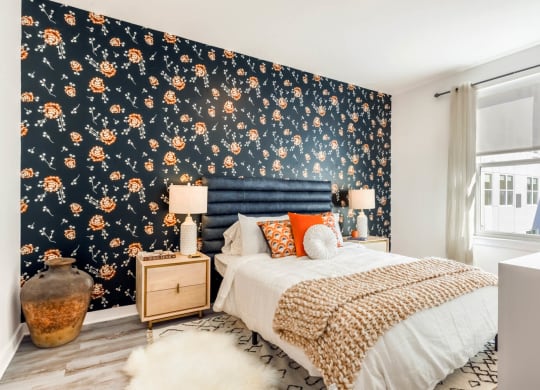 Model bedroom with a bed and a dark wallpaper