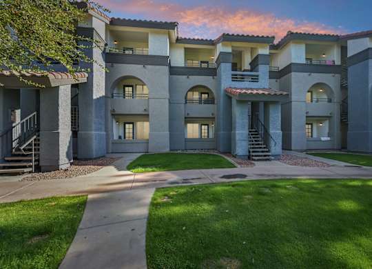Sunset view of Stillwater apartment buildings with a courtyard in the foreground.