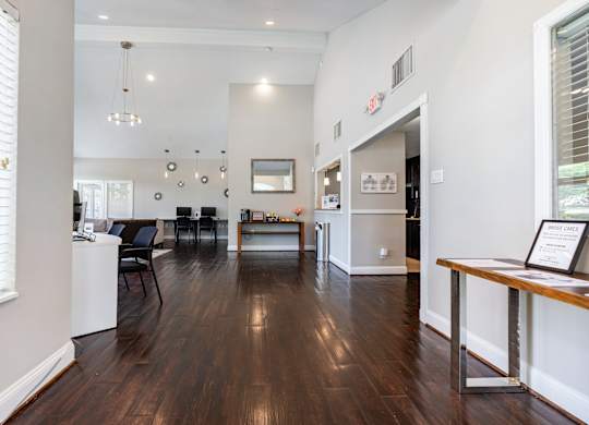 A modern living room with dark wood floors and white walls.