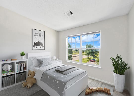 Model Bedroom with Carpet and Window View at The Commons at Haynes Farm Apartments in Boston, MA.