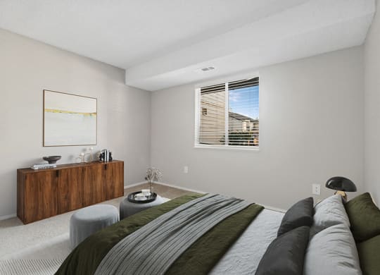 Model Bedroom with Carpet and Window View at Liberty Creek Apartments in Aurora, CO.
