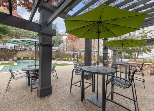 Outdoor BBQ Area with Furniture and Canopy at Bridges at Oakbend Apartments in Lewisville, TX.