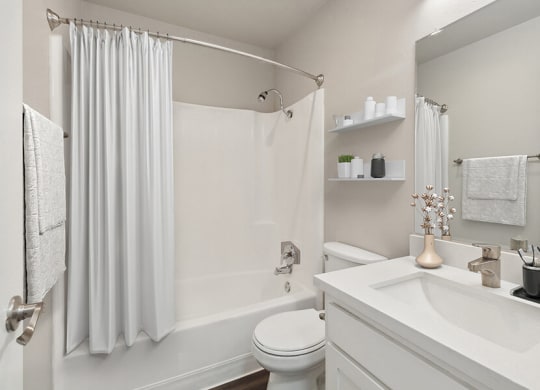 Model Bathroom with White Cabinets, Wood-Style Flooring and Shower/Tub at Colonnade at Fletcher Hills Apartments in El Cajon, CA.