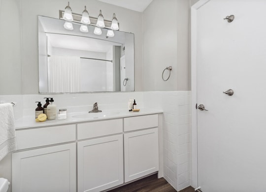 Model bathroom with a sink and a mirror  at Stone Ends apartments in Stoughton, MA