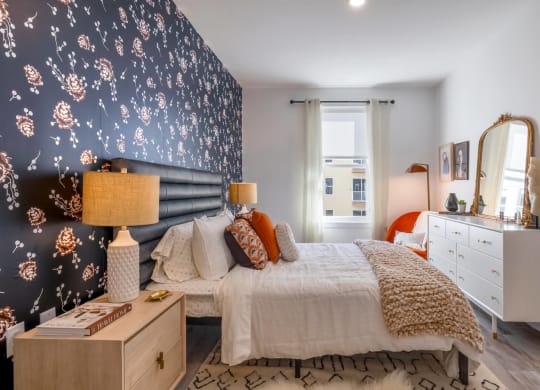 Model bedroom with a bed and blue wallpaper