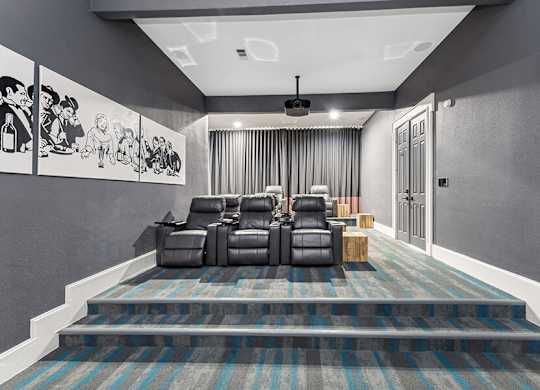 Community Theater Room with Lounge Chairs and Projector Screen at Chapel Hill Apartments located in Lewisville, TX.