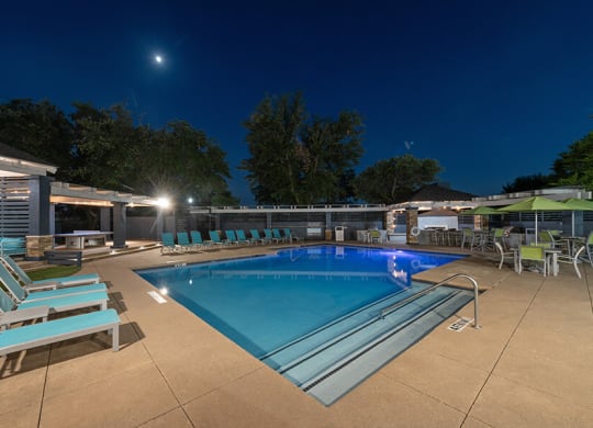 Community Swimming Pool with Pool Furniture at Essence North Dallas Apartments located in Dallas, TX.