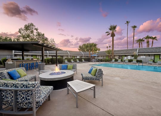 Outdoor Fire Pit Area and Swimming Pool with Lounge Furniture at Arcadia on 49th Apartments located in Phoenix, AZ.